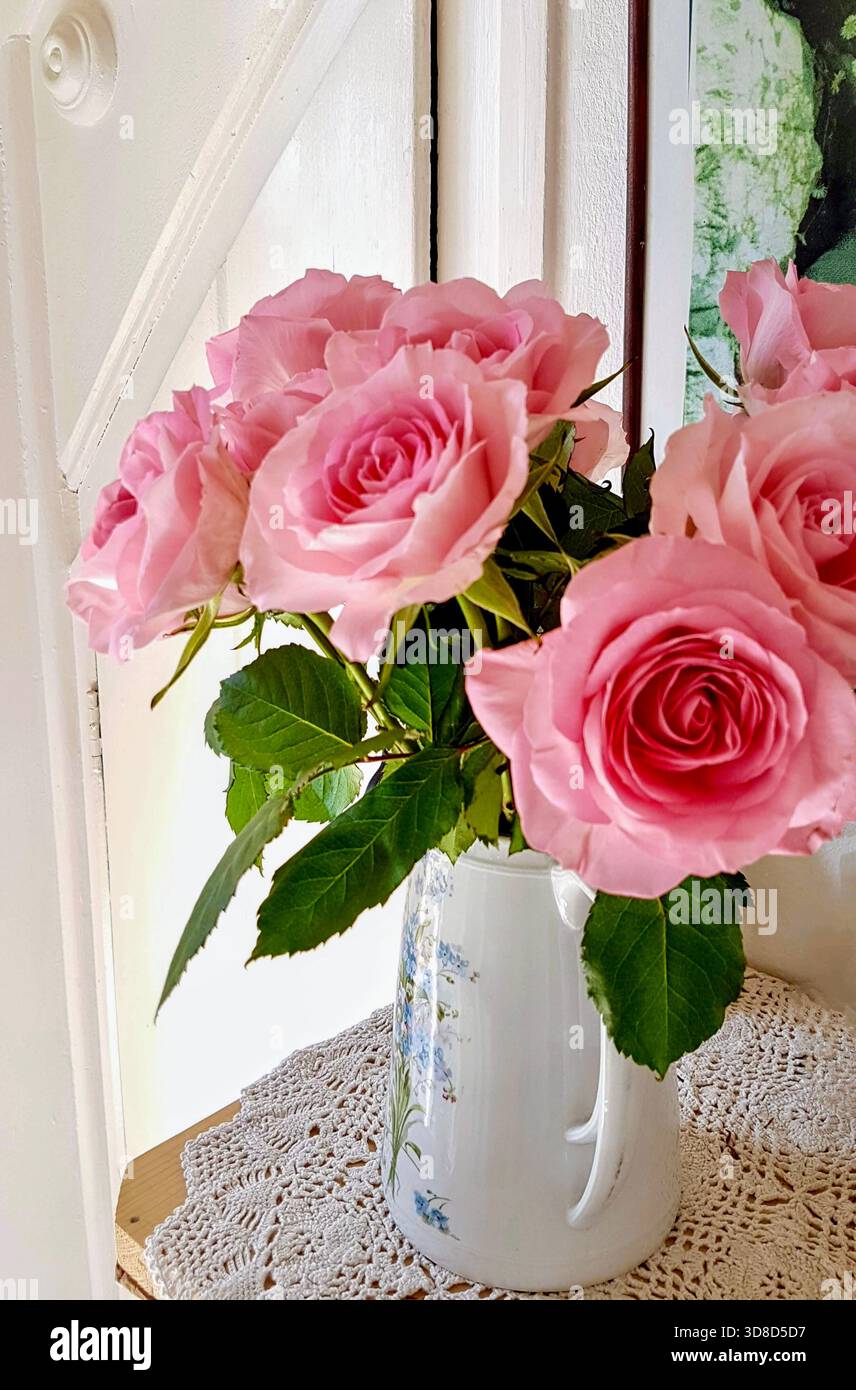 Styled Roses A beautiful arrangement of soft pink roses displayed in an antique vase ...