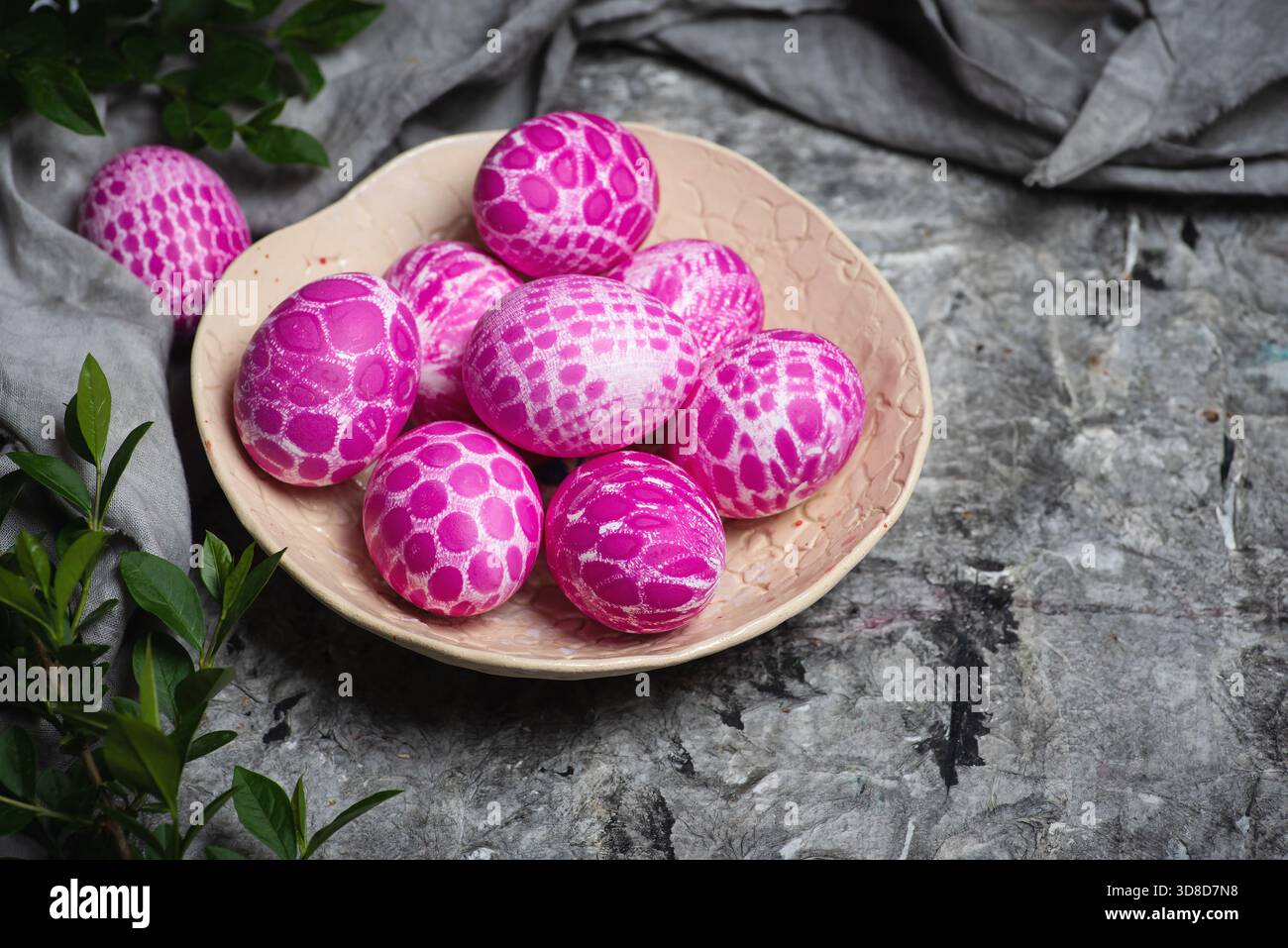 Lace pattern painted pink Easter eggs on a plate on gray background with copy space top view. Easter holiday background Stock Photo