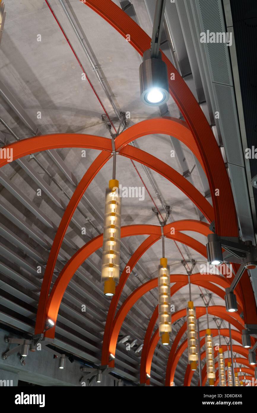 Melbourne, VIC, Australia. November 30, 2025. - The dynamic ceiling architecture of Town Hall Station features repeating bright orange arches and cont Stock Photo
