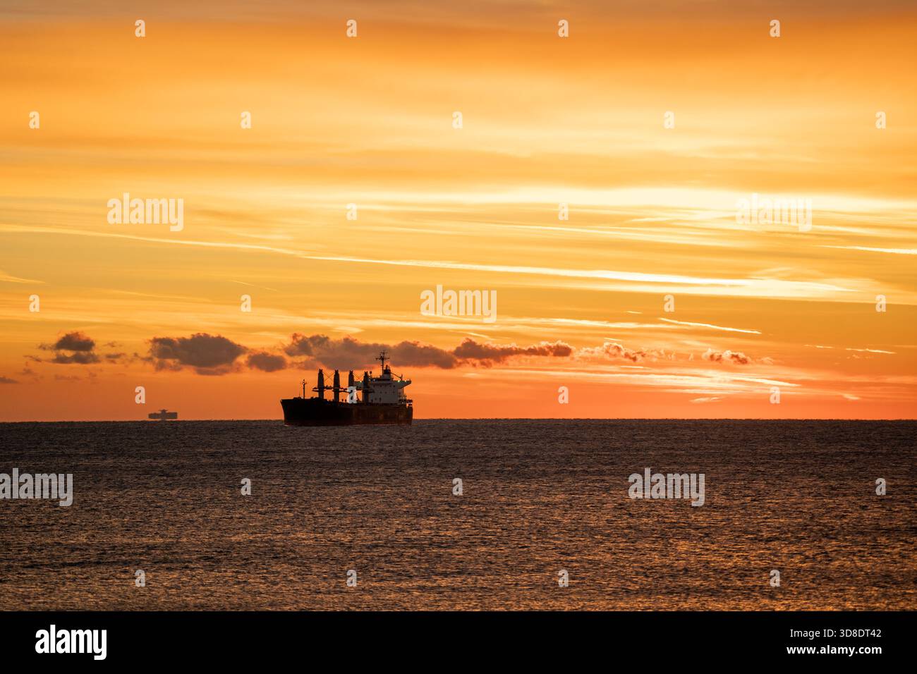 morning maritime scene, shoreline cargo ship bathed in morning light ...