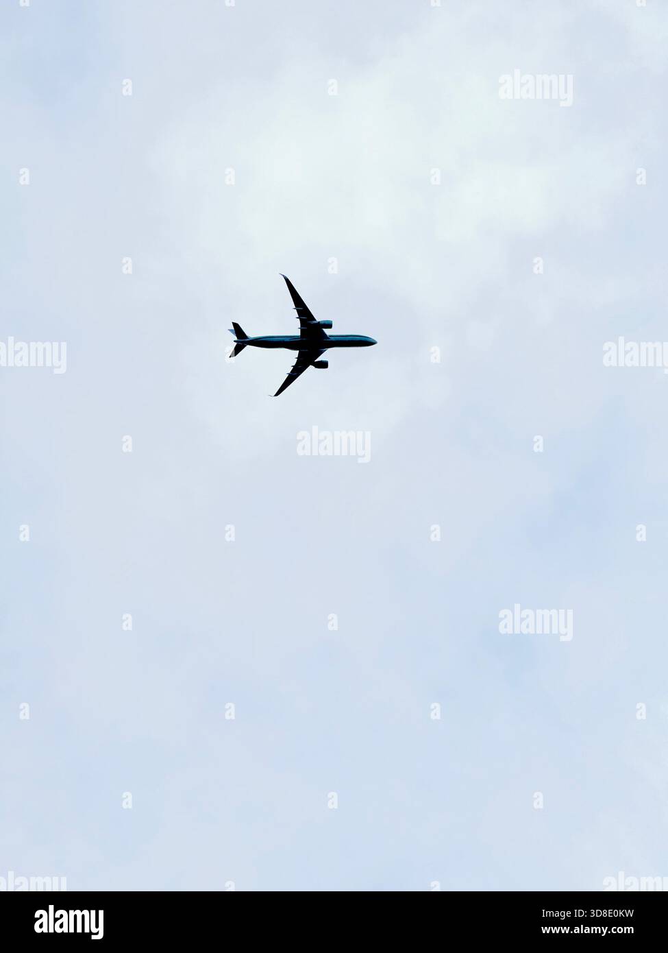 Commercial airplane flying overhead against a cloudy sky. - Smartphone Captured Stock Image
