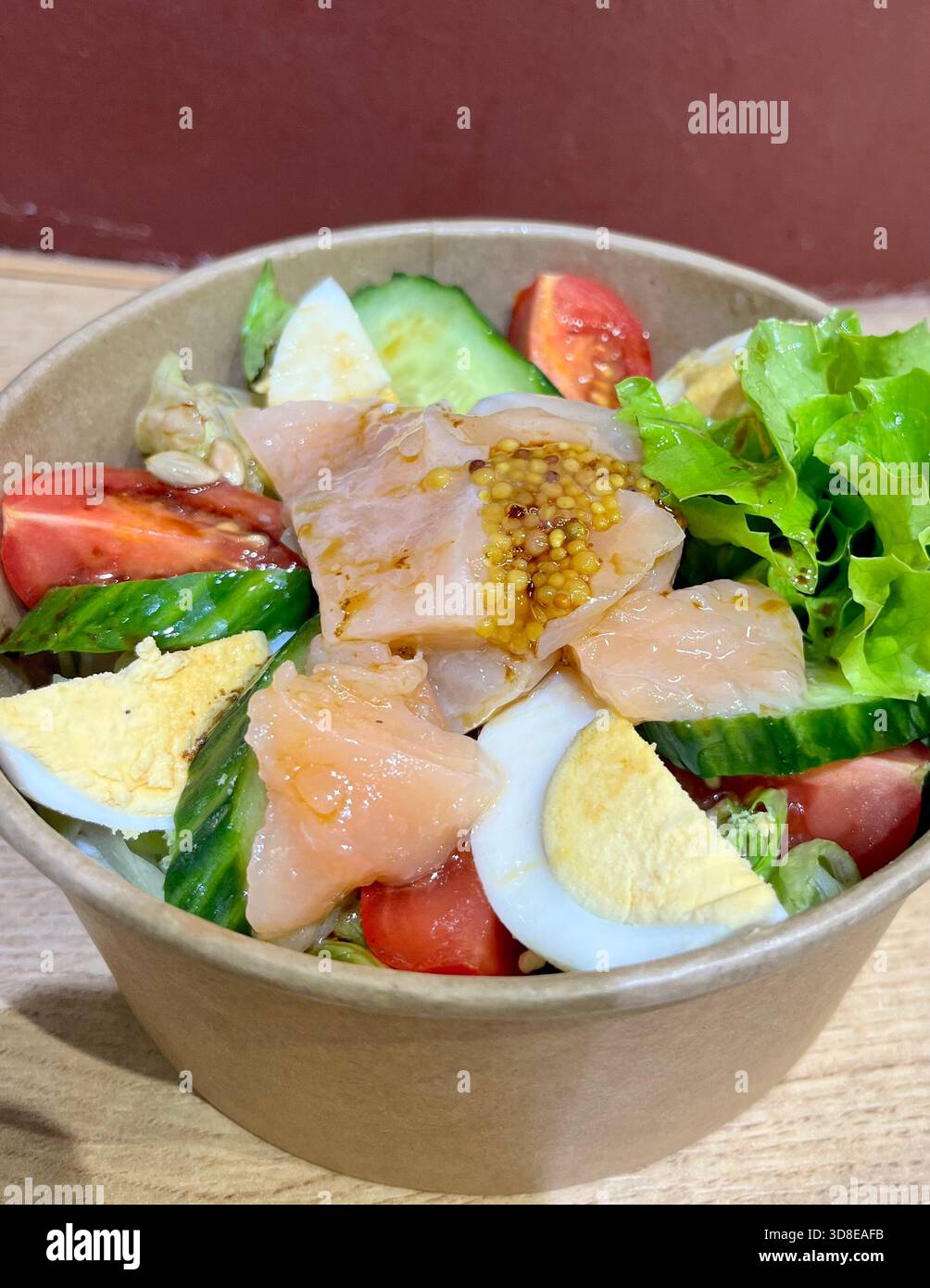 Smoked salmon, boiled egg, and fresh vegetables salad in paper poke bowl, café take away veg and salmon salad - Smartphone Captured Stock Image
