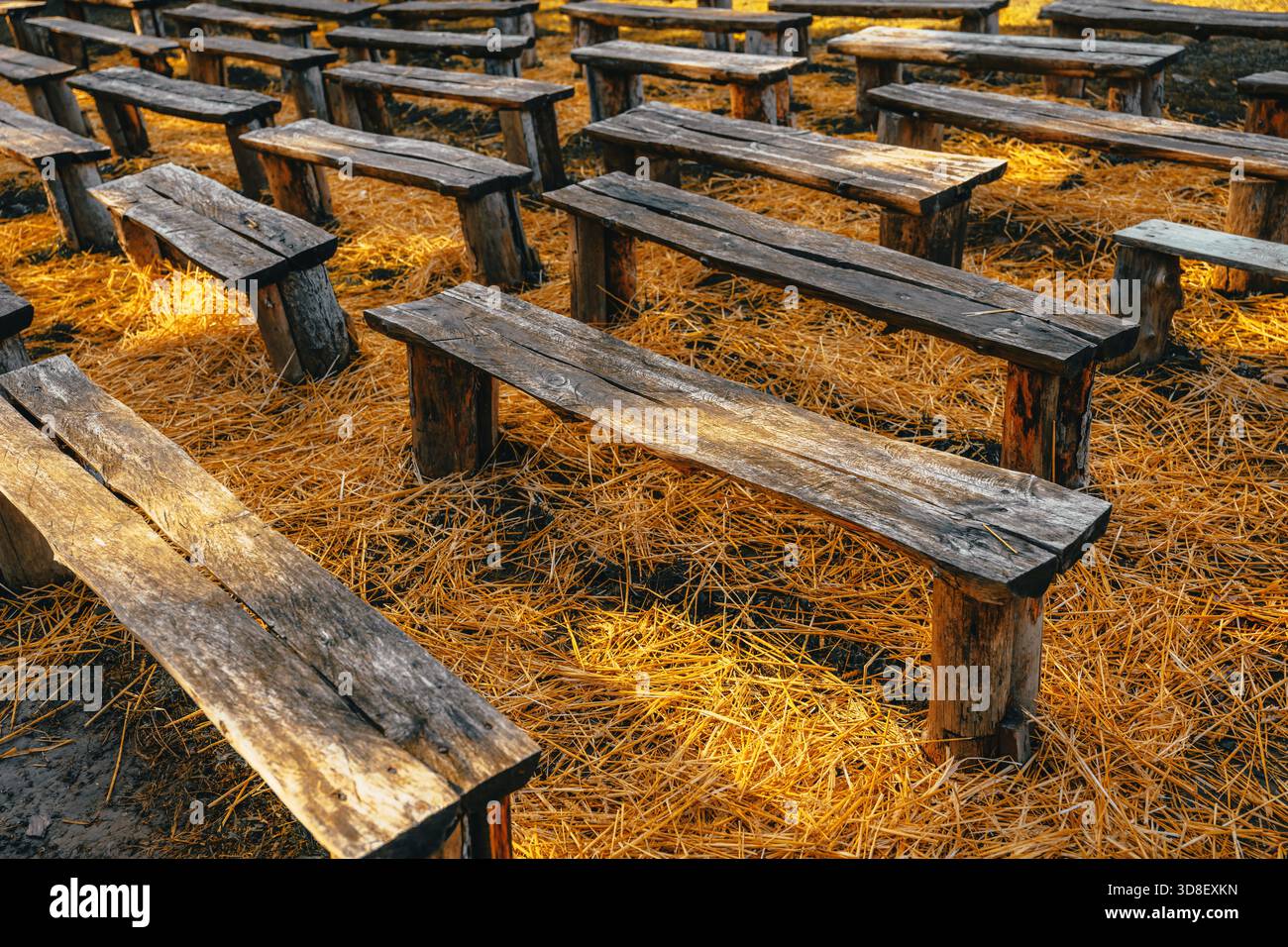 Old handmade wooden seating benches placed on hay in countryside ...