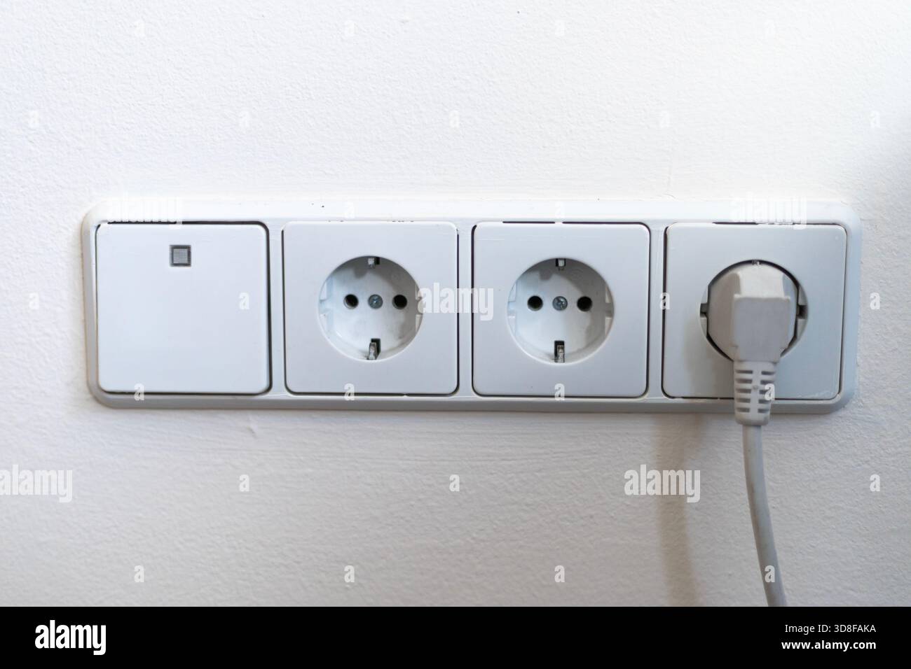 Electrical outlets and light switch on the wall Stock Photo