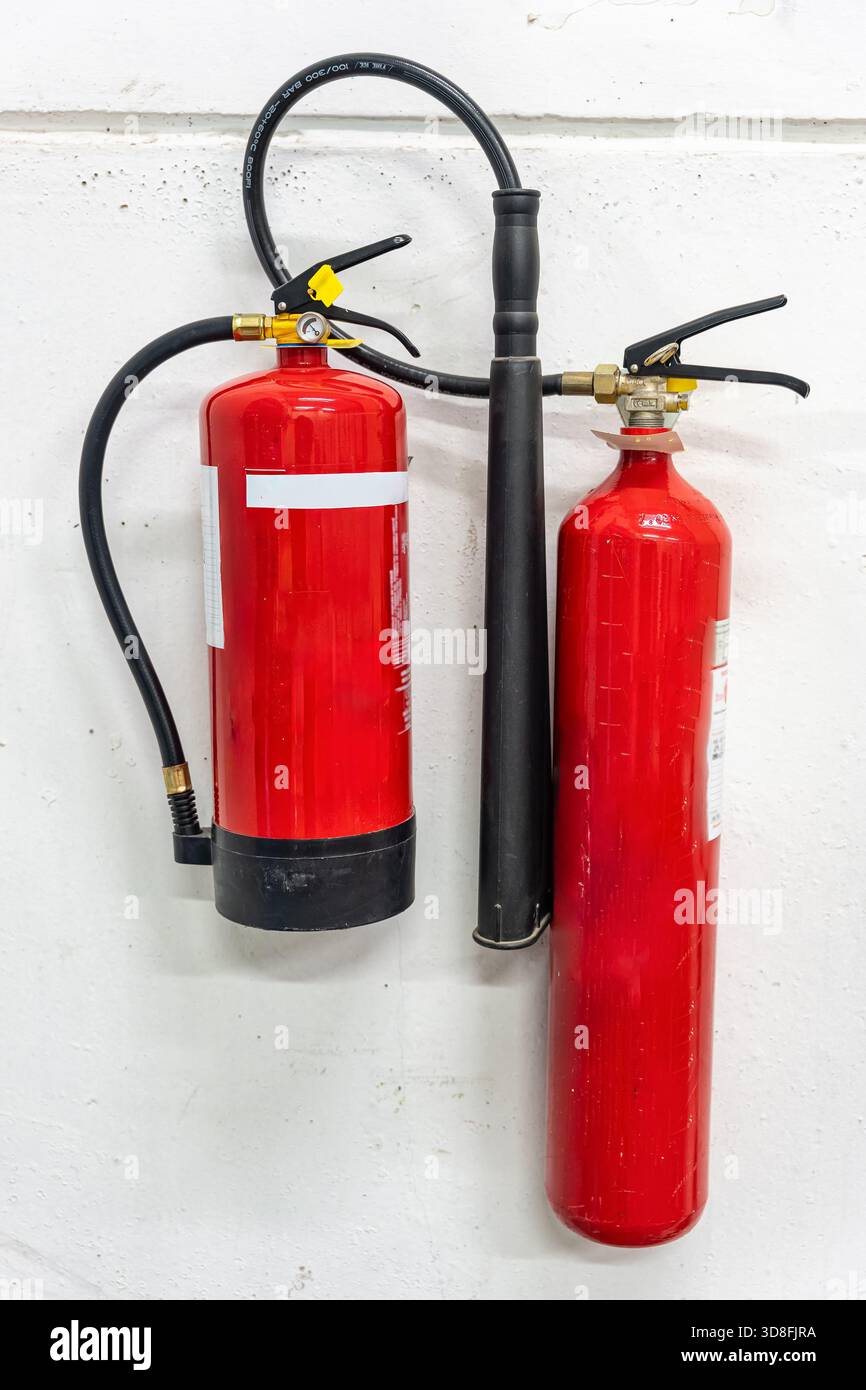 two fire extinguishers of different sizes and for different types of fire in industrial installations. Stock Photo