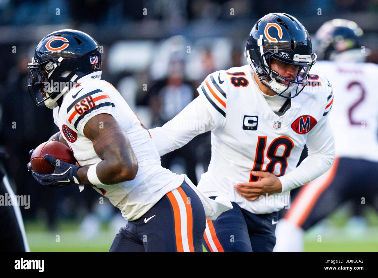 Chicago Bears quarterback Caleb Williams, right, hands the ball off to ...