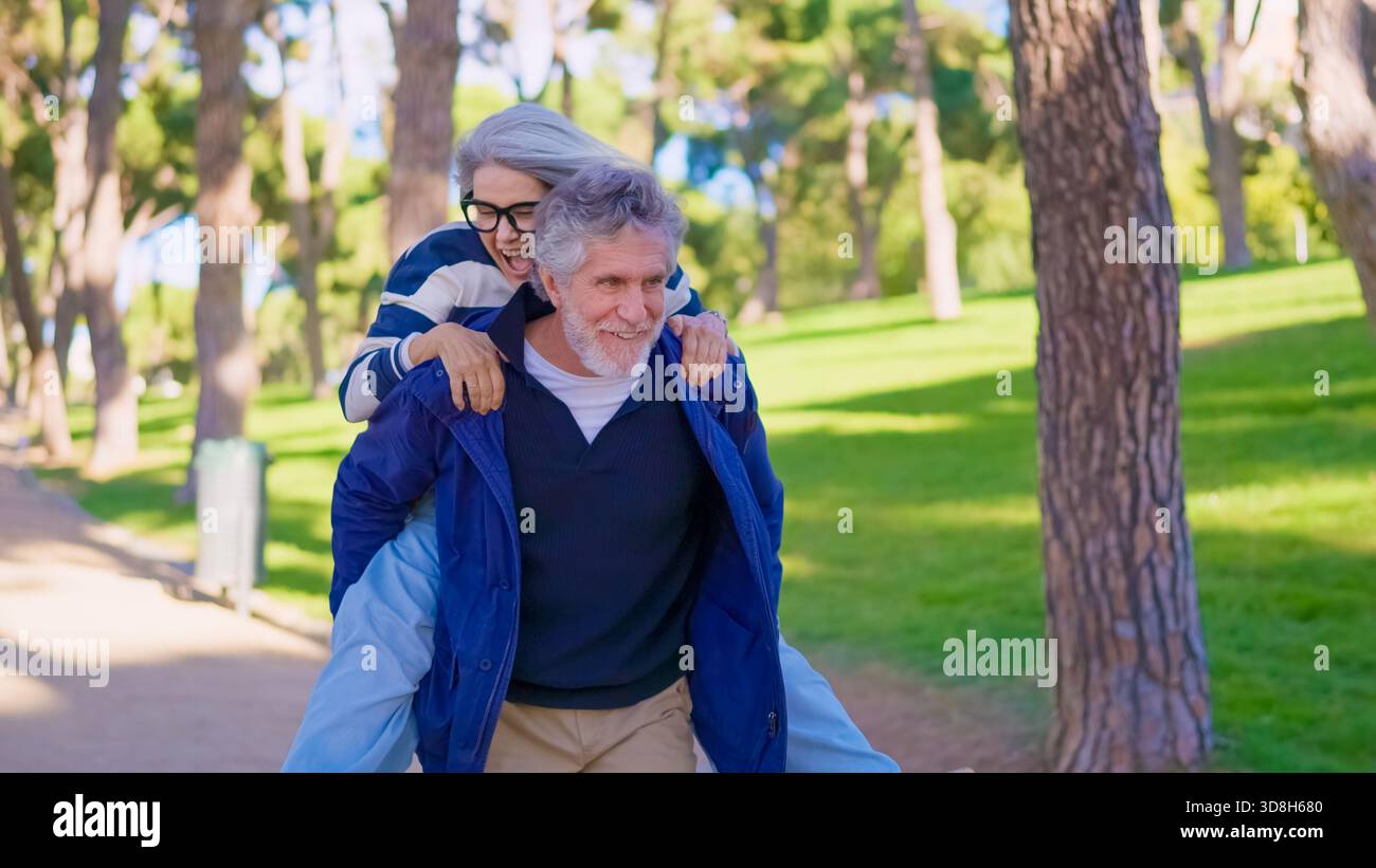 Playful senior couple having fun with a piggyback ride Stock Photo