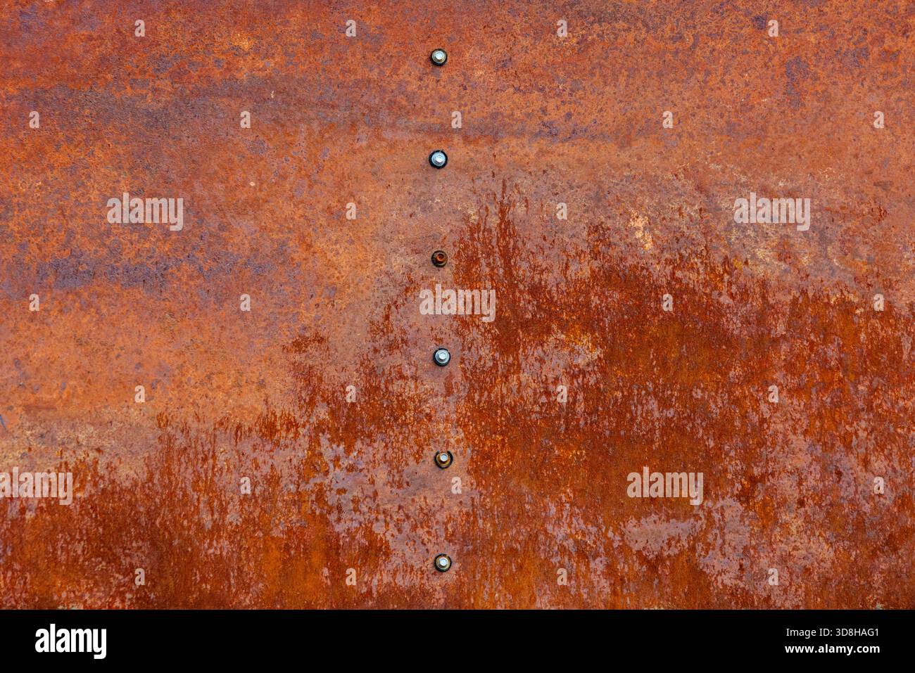 Rusty metal row of hexagonal screws or bolt heads Stock Photo