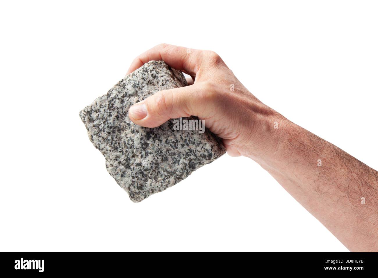 Human hand holding a pave granite stone cube down Stock Photo