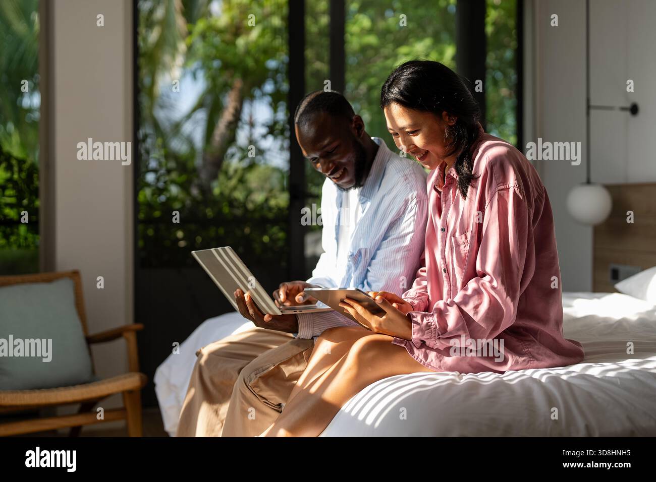 Couple of freelance IT specialists using digital technology devices while working remotely from home Stock Photo