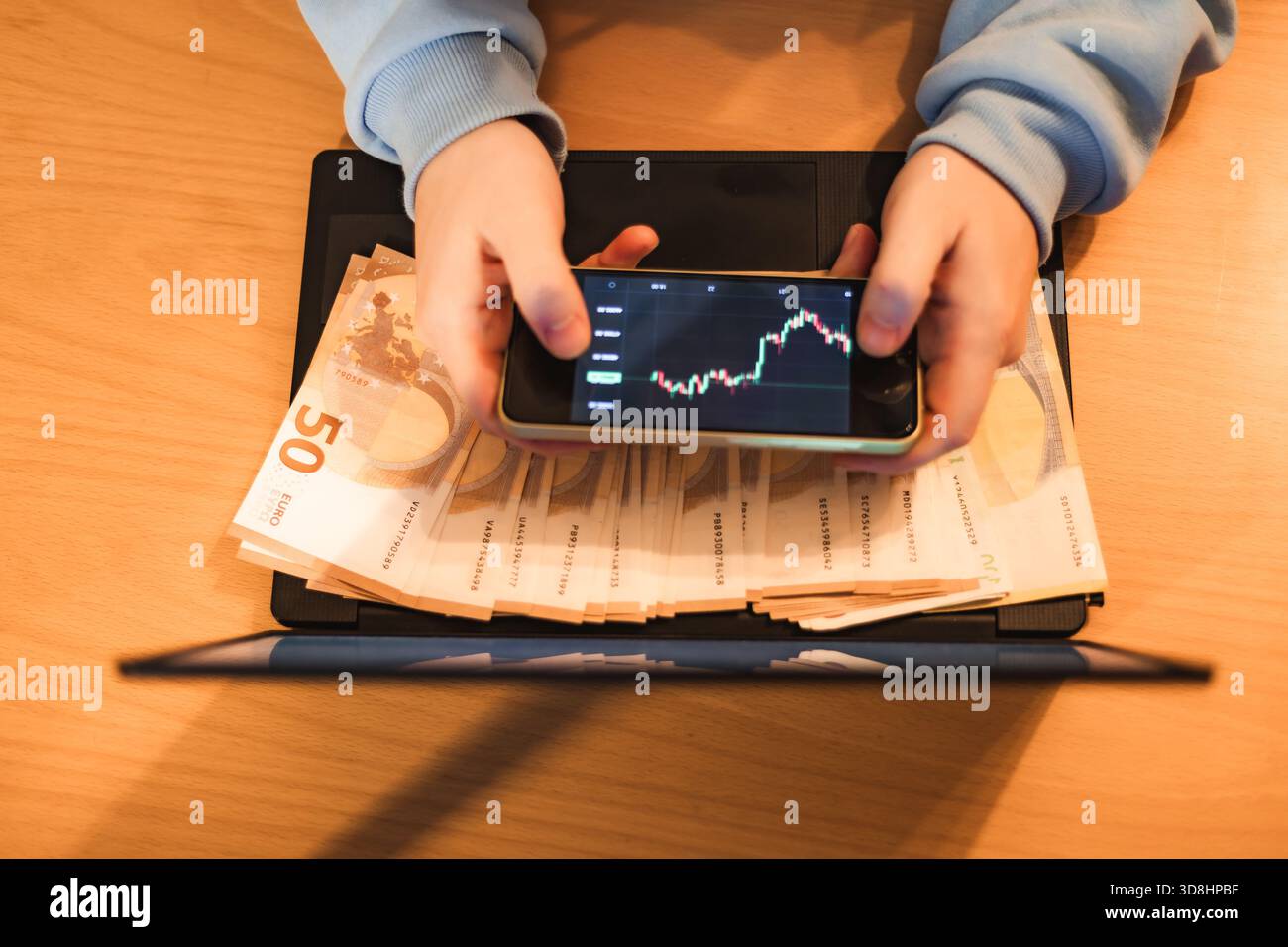Close-up photo of hands holding euro banknotes while using a laptop and  smartphone showing cryptocurrency charts. Perfect for fintech, crypto  trading Stock Photo - Alamy