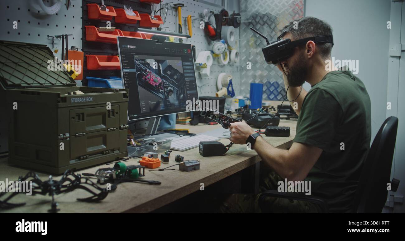 Engineer Using VR Goggles to Virtually Design. Man in Military Style Uniform Utilizing VR Goggles and Computer While Assembling Drone Components. Concept Integration of Virtual Tools in Engineering. Stock Photo