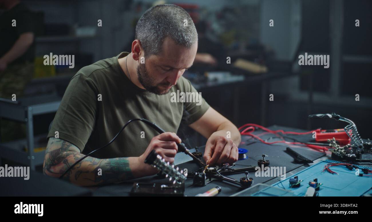 Worker With Tattoo on Arm Soldering Internal Electronics Onto ...