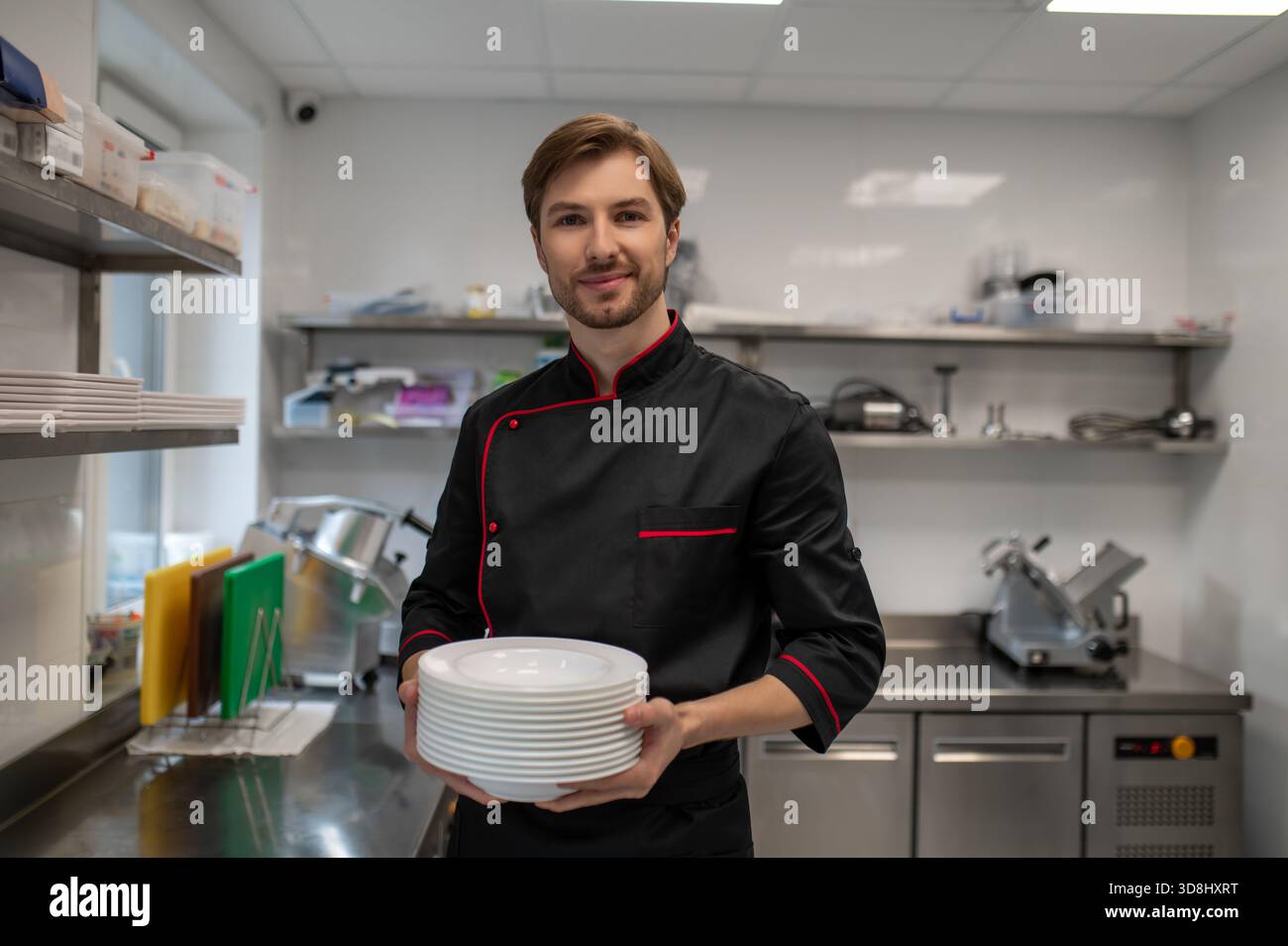 Professional chef holding stack of plates in restaurant kitchen Stock ...