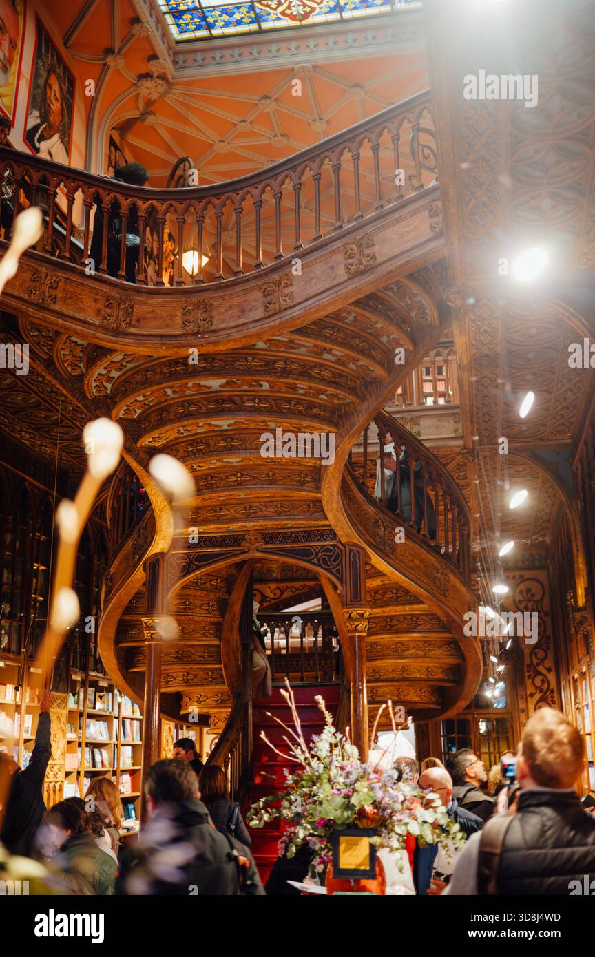 Visitors Inside Livraria Lello with Ornate Wooden Staircase, Porto Stock Photo