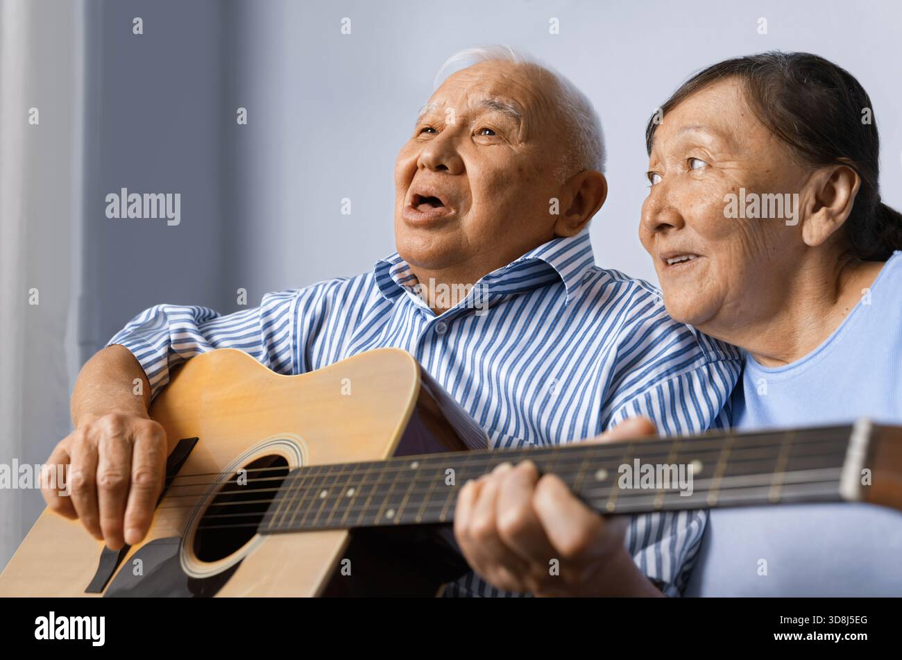 Senior man playing acoustic guitar with his wife Stock Photo