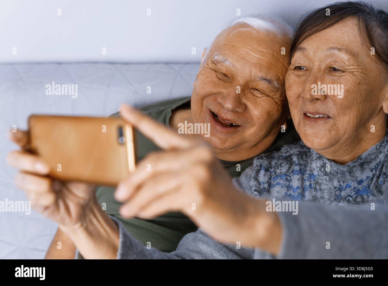 Senior couple at home taking a selfie Stock Photo