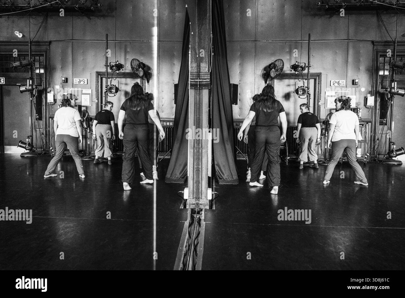 Dancers rehearsing in studio with mirror reflection Stock Photo