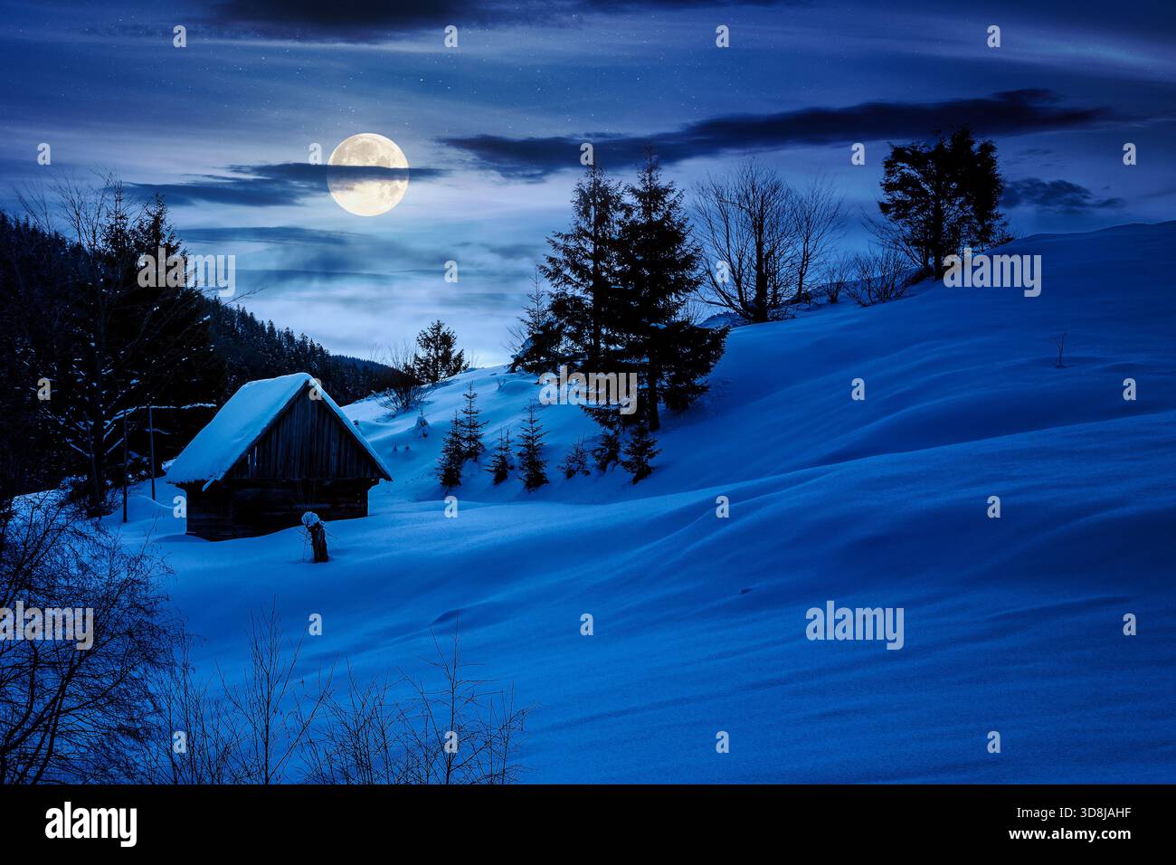 beautiful winter landscape with snow covered hills at night. serene rural scene in mountains in full moon light. rolling countryside area. christmas b Stock Photo