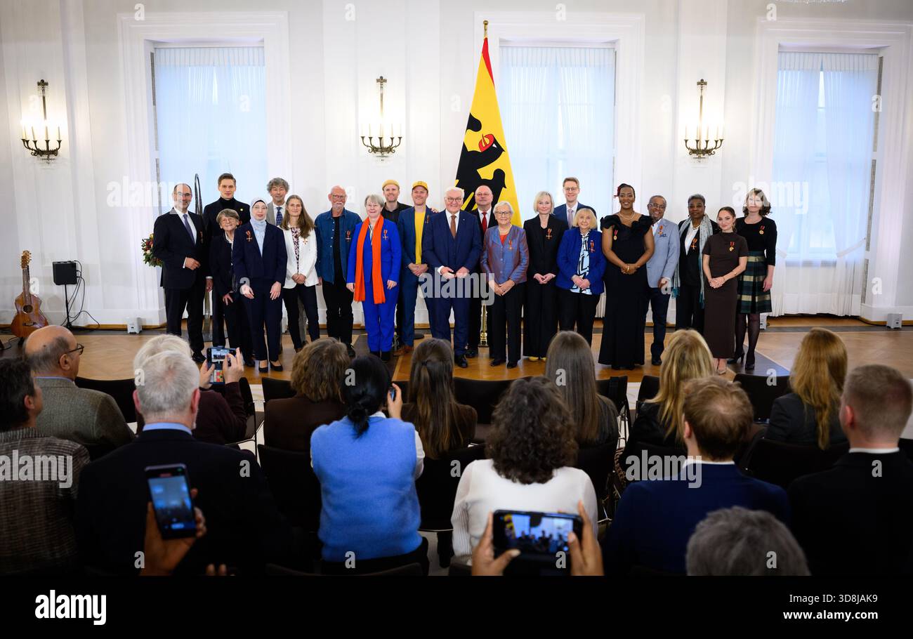 Berlin, Germany. 01st Dec, 2025. Federal President Frank-Walter Steinmeier (M) stands with the honorees for a group photo after the awarding of the Order of Merit of the Federal Republic of Germany at Bellevue Palace. Under the motto 'Germany in the World', the Federal President is today awarding the Order of Merit to eleven women and nine men for their outstanding commitment on International Volunteer Day on December 5. Credit: Bernd von Jutrczenka/dpa/Alamy Live News Stock Photo