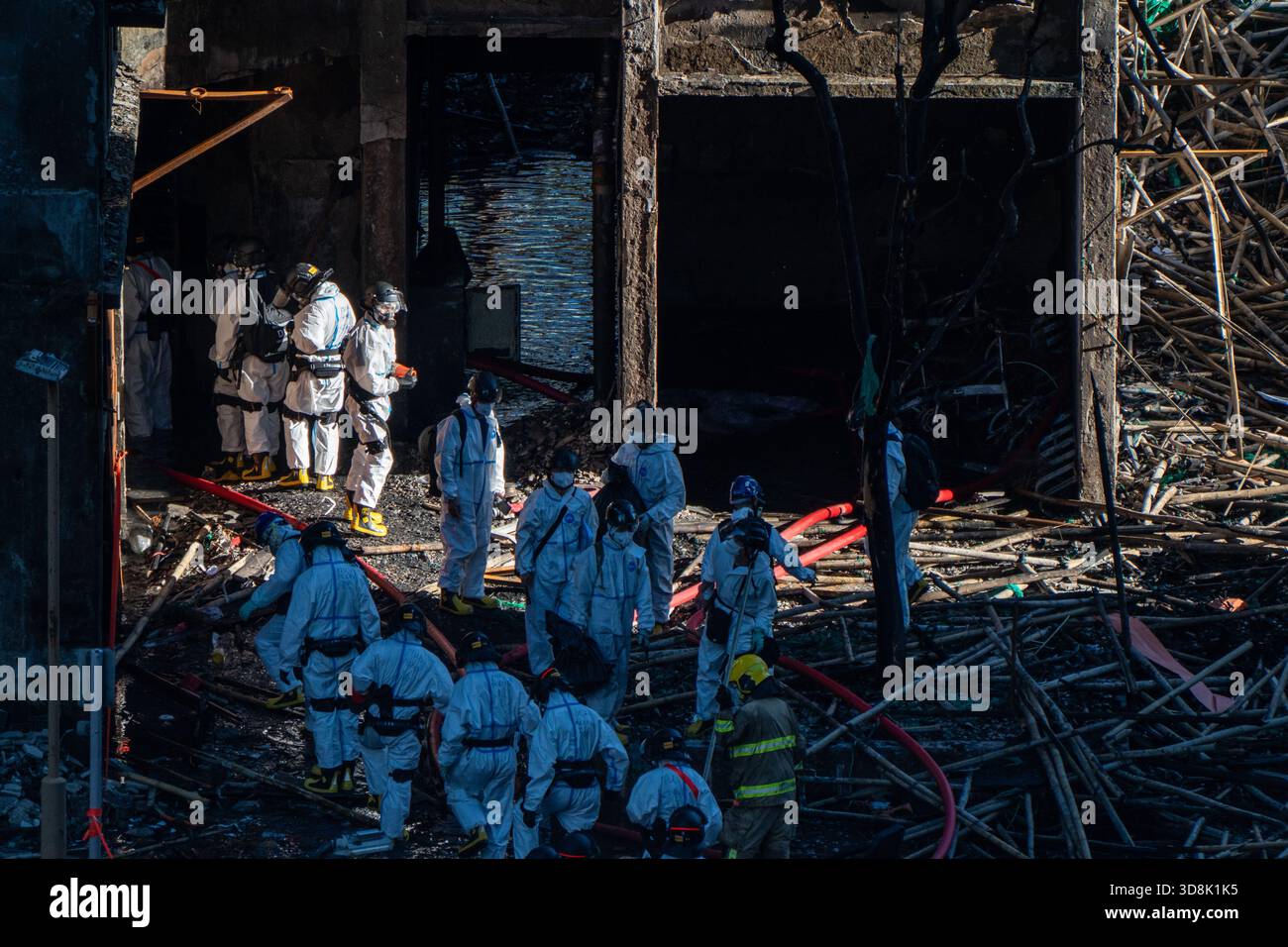 Hong Kong. 1 Dec, 2025. Police officers leaving one of the burned buildings at Wang Fuk Court housing complex in Tai Po following a deadly fire on December 1, 2025 in Hong Kong. (Photo by Vernon Yuen/Nexpher Images) Credit: Nexpher Images Limited/Alamy Live News Credit: Nexpher Images Limited/Alamy Live News Stock Photo