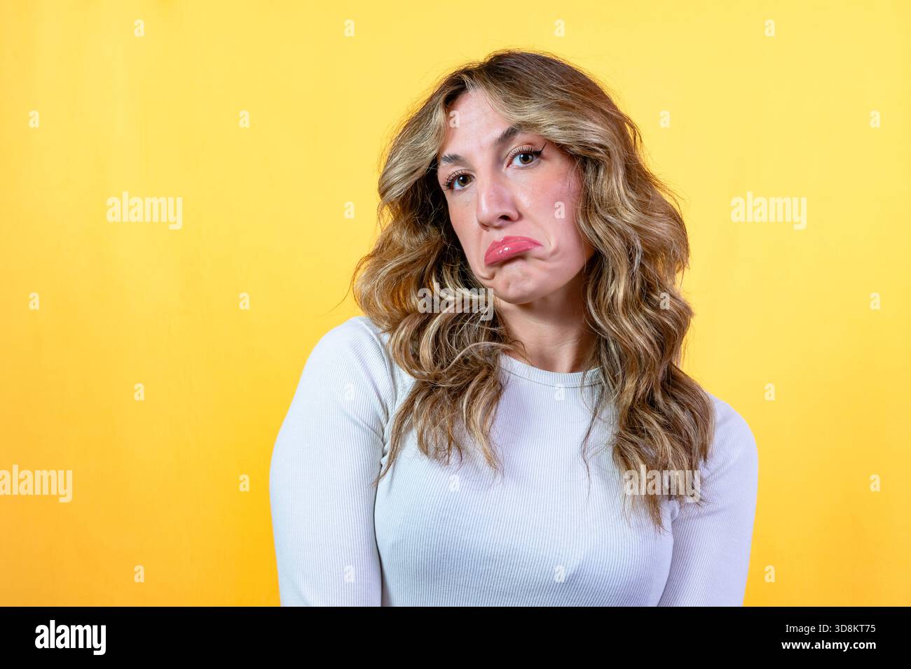 Woman making a sad face, pouting her lips demonstrating disappointment Stock Photo