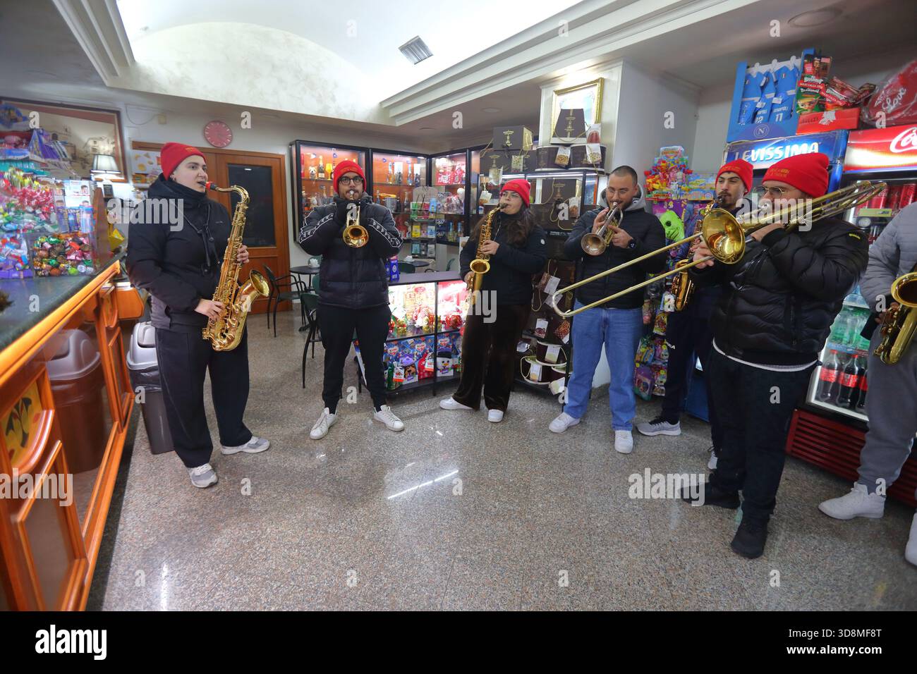 Young musicians play the night on the streets of the city to announce the start of the Christmas holidays. - Stock Image