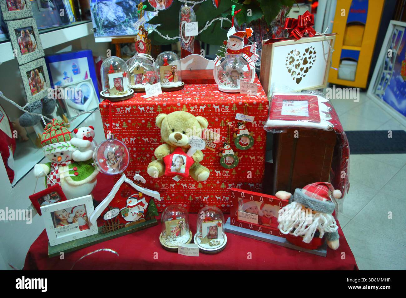 Christmas gifts seen inside a shop window. - Stock Image