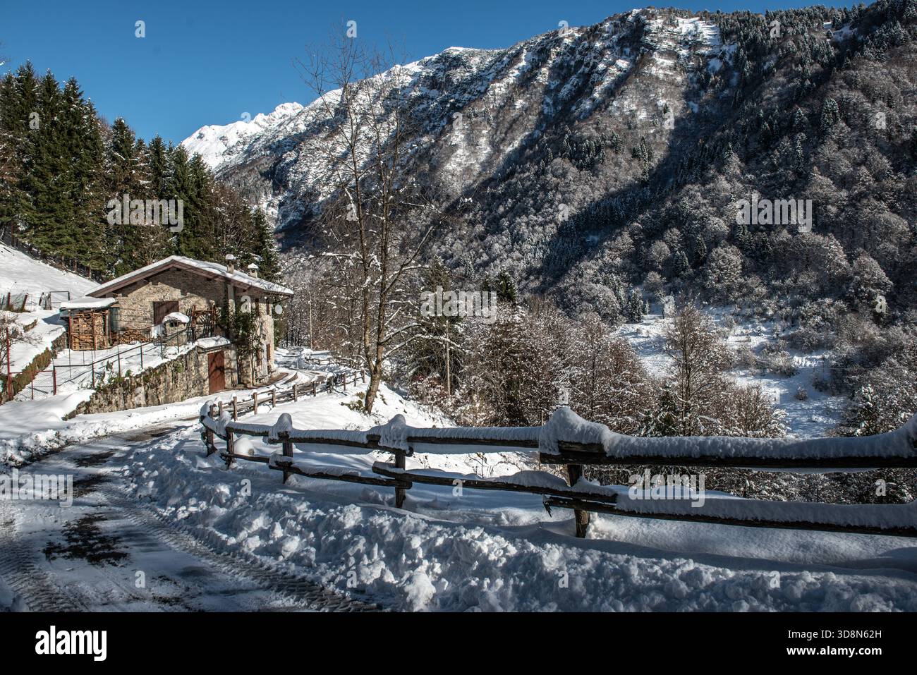 Snowy mountain road with fence Stock Photo
