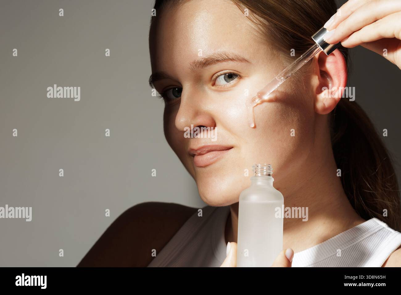 Young woman using glass dropper hi-res stock photography and images - Alamy