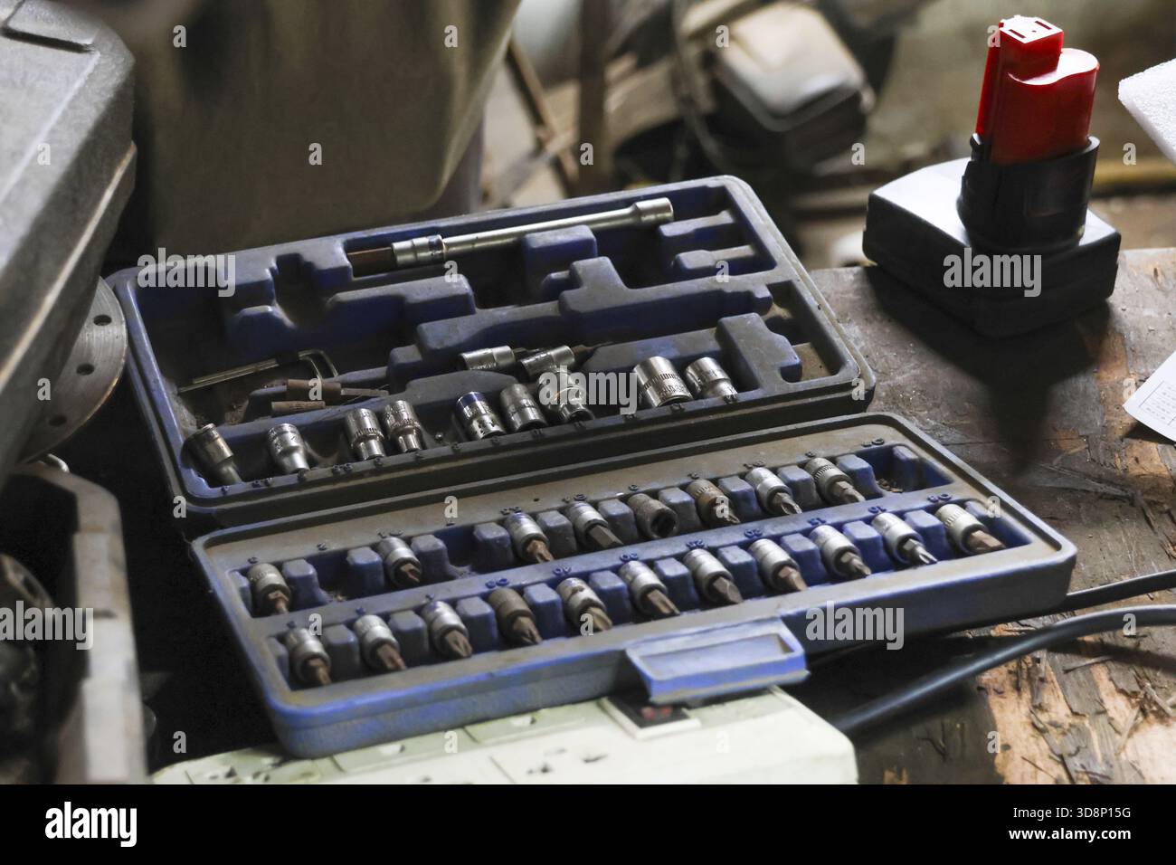 Open socket wrench set with various metal tools organized in case on workbench. This mechanic and repair equipment ready for DIY project or automotive Stock Photo
