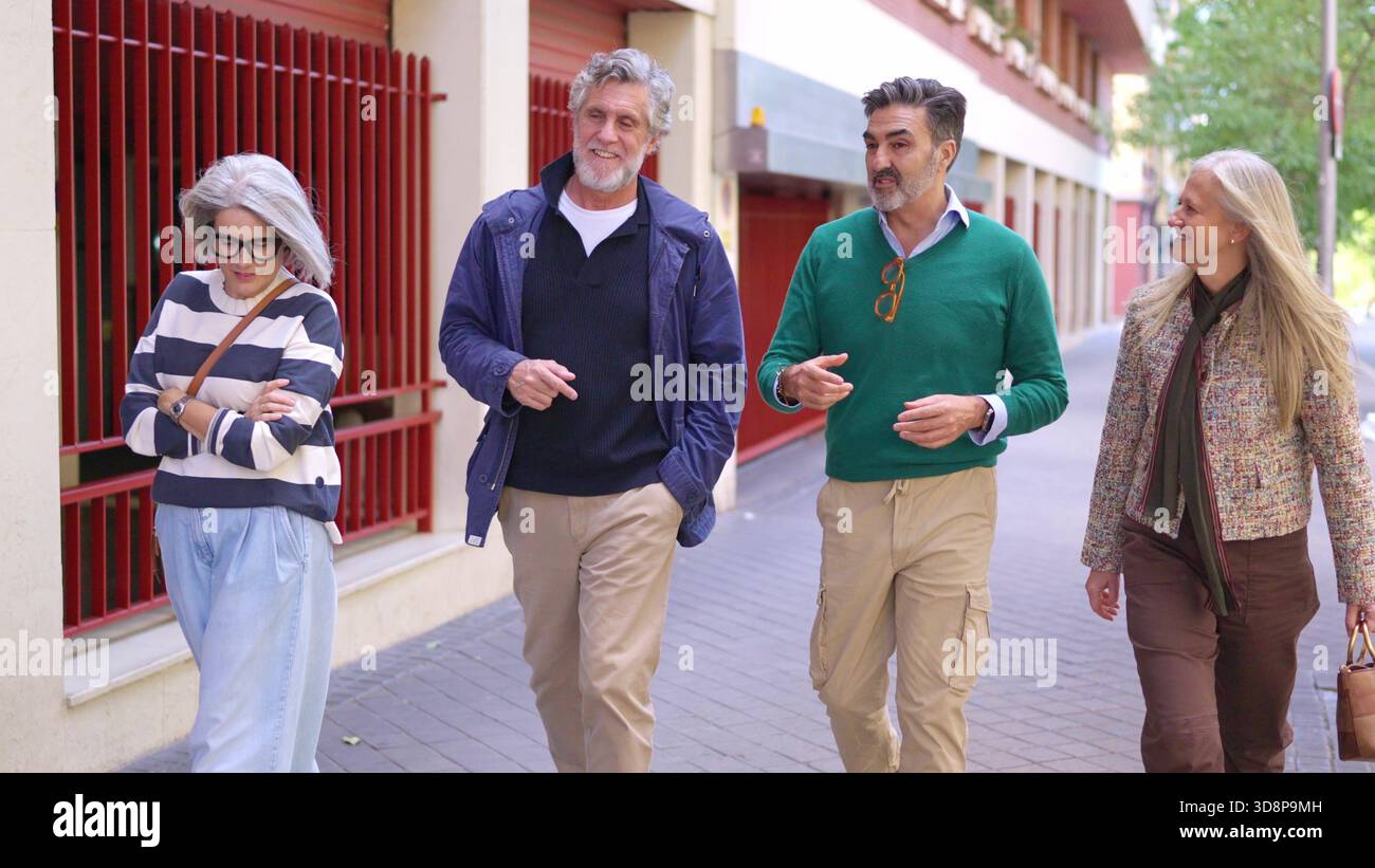 Two senior men talking while walking outdoors Stock Photo
