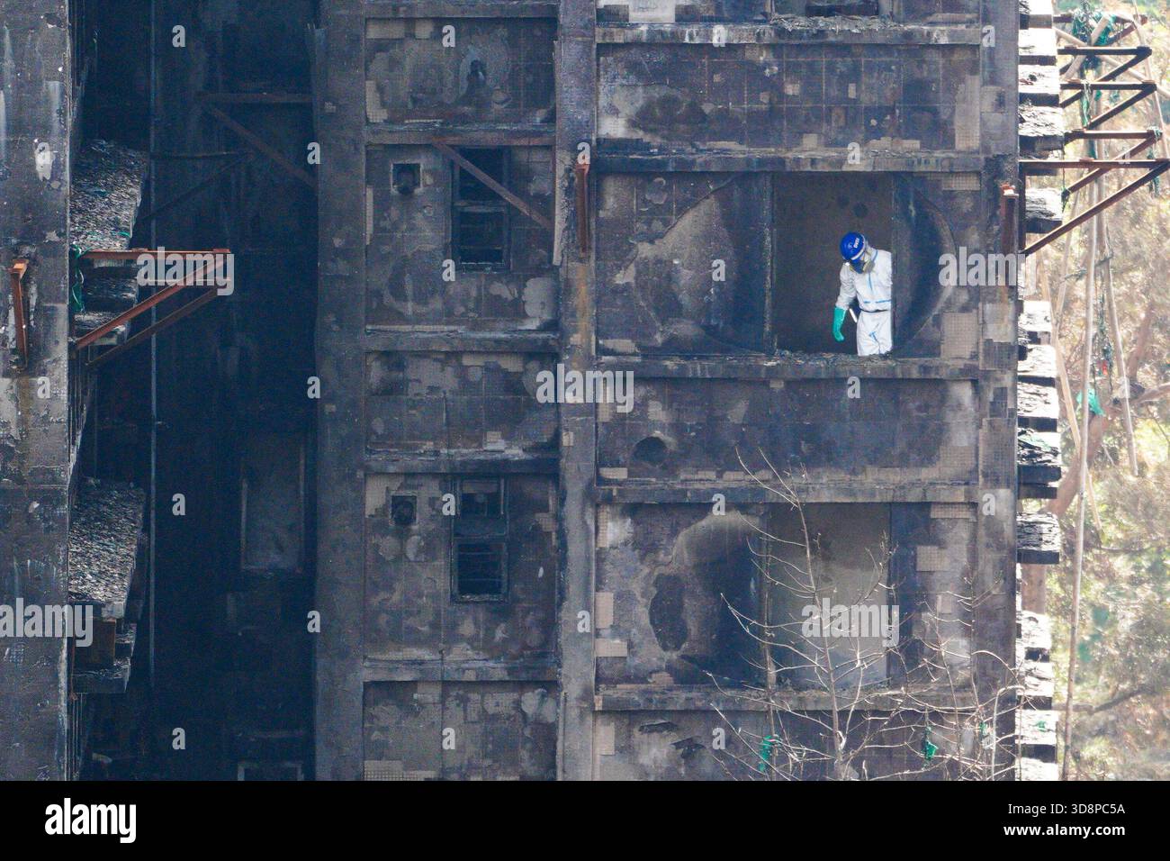 Hong Kong. 02nd Dec, 2025. A Police officer inside one of the burned buildings at Wang Fuk Court housing complex in Tai Po following a deadly fire on December 2, 2025 in Hong Kong. (Photo by Ellan Mad/Nexpher Images) Credit: Nexpher Images Limited/Alamy Live News Stock Photo