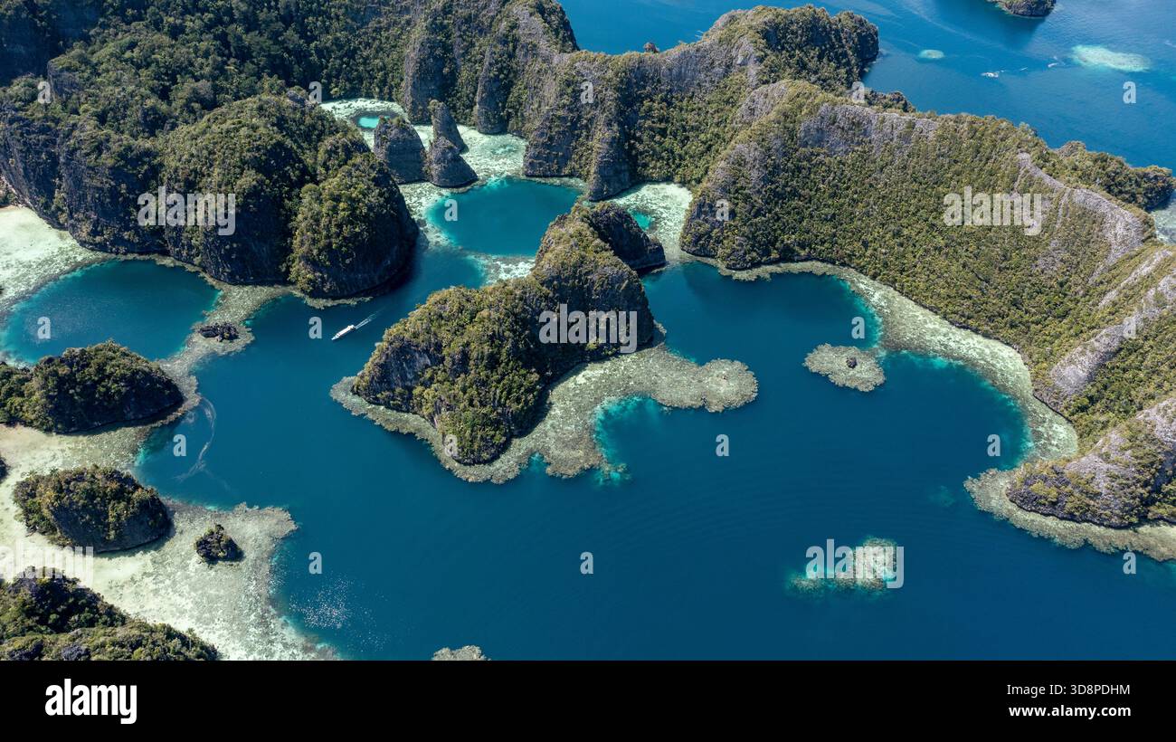 Masool Raja Island An aerial view of a speed boat driving through Balbulol lagoon, Misool ...