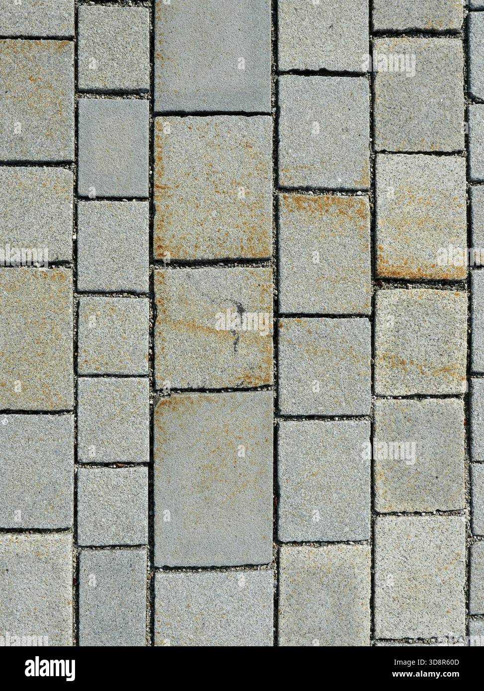 Granite pavement with rough texture, varying gray tones, and natural discoloration. Close-up. Copyspace. Stock Photo