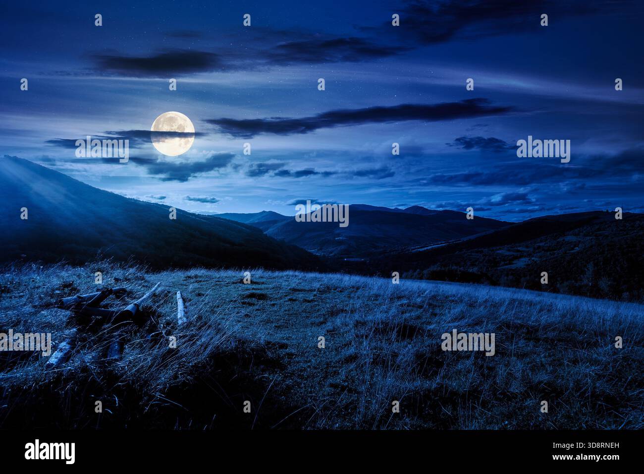 beautiful countryside at night. wonderful summertime landscape in mountains in full moon light. scenic view of grassy field and rolling hills. backgro Stock Photo