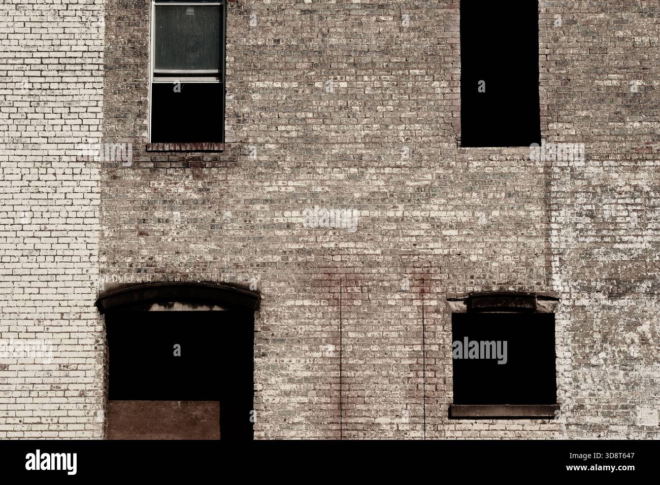 Brick facade and empty windows on old building Stock Photo