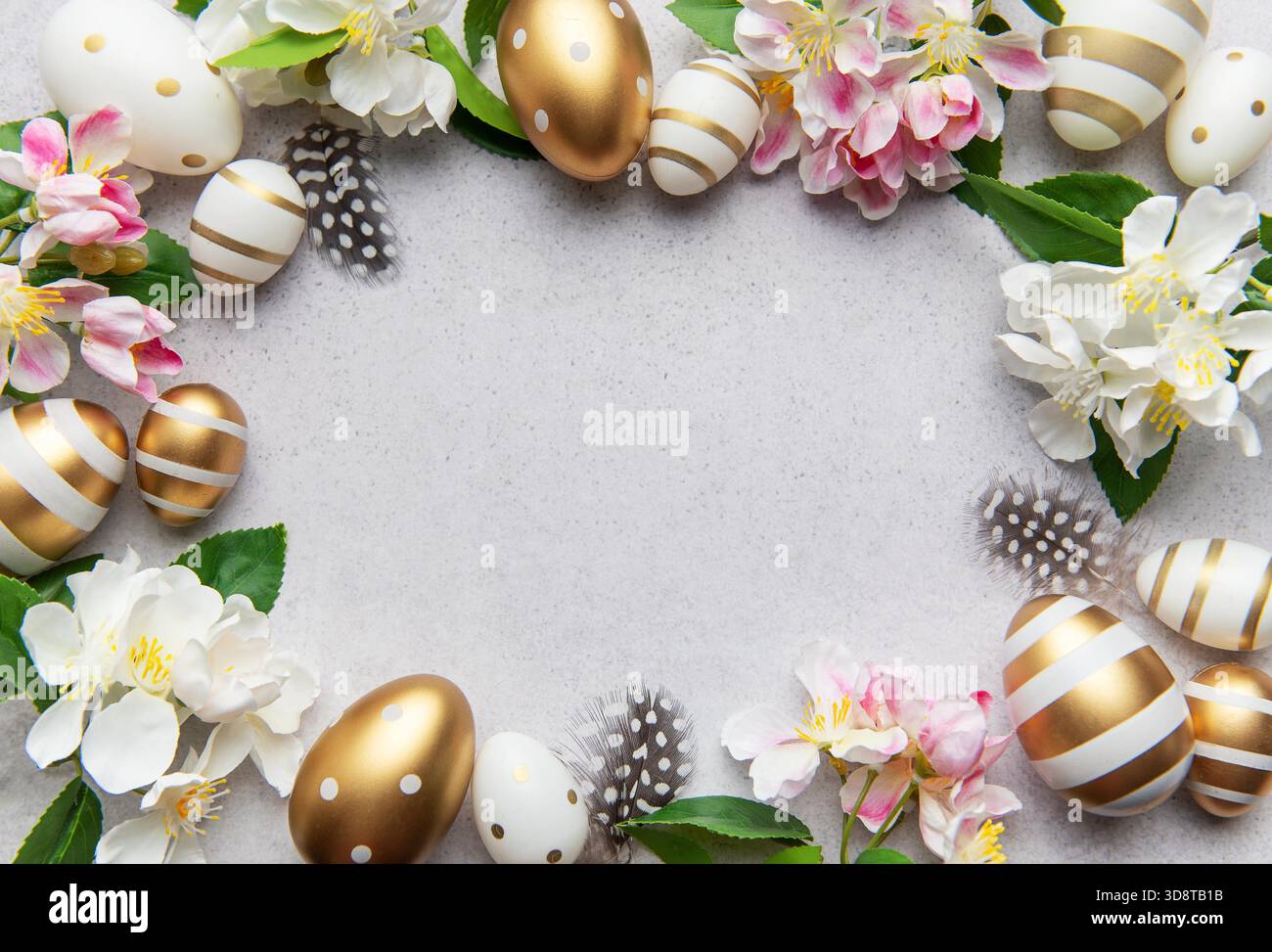 Golden eggs and flowers create a festive easter border on a light background Stock Photo