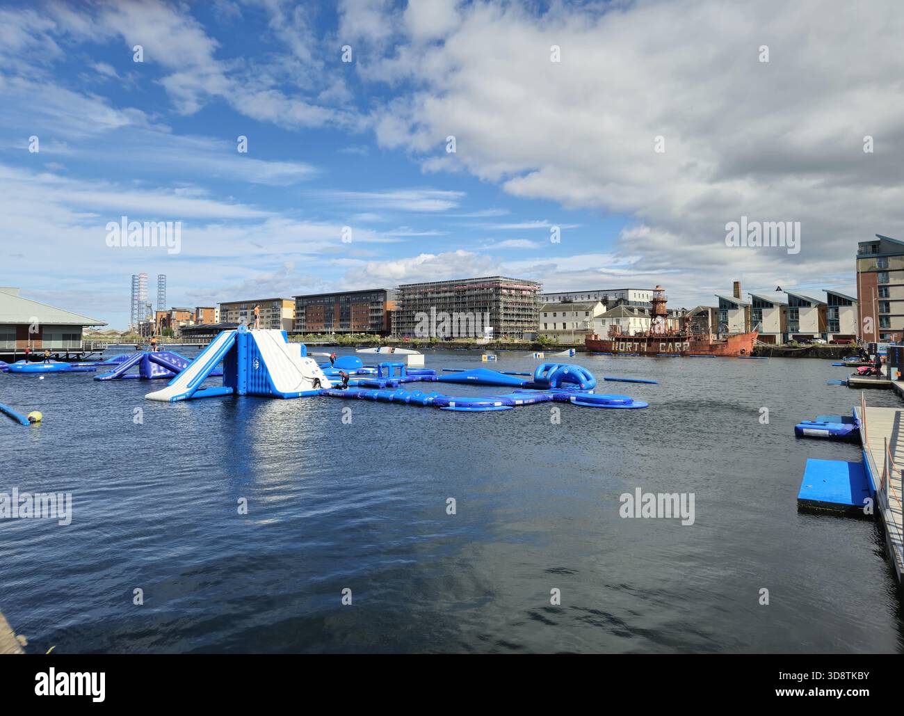 Watersports and aqua park, Wild Shore Dundee near the City Quay. At the background, North Carr, a lightship moored in Victoria Dock, Dundee, Scotland Stock Photo