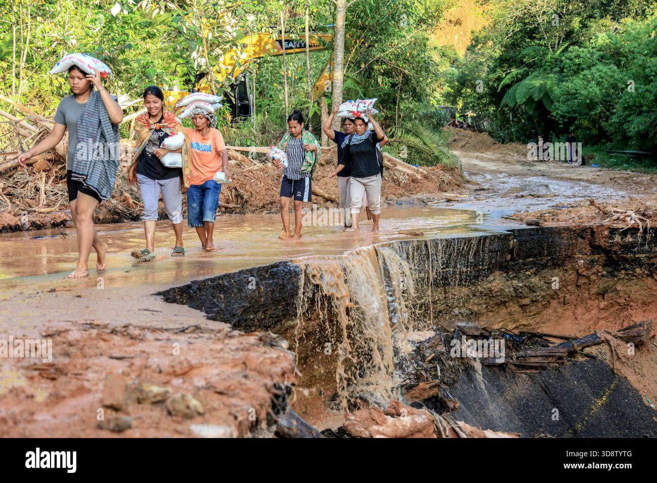 Jakarta, Indonesia. 2nd Dec, 2025. People carry disaster relief supplies at a flood-hit village in North Tapanuli Regency, North Sumatra, Indonesia, Dec. 2, 2025. The death toll from recent floods and landslides across three provinces on Indonesia's Sumatra Island has risen to 712, with 507 people still missing, the National Disaster Management Agency (BNPB) said on Tuesday. Credit: Alberth Damanik/Xinhua/Alamy Live News Stock Photo