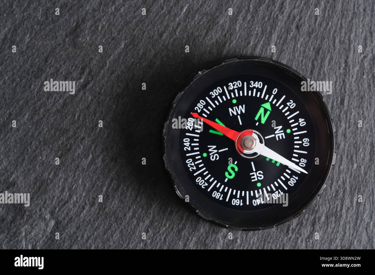 Compass on dark stone background. Top view with copy space Stock Photo