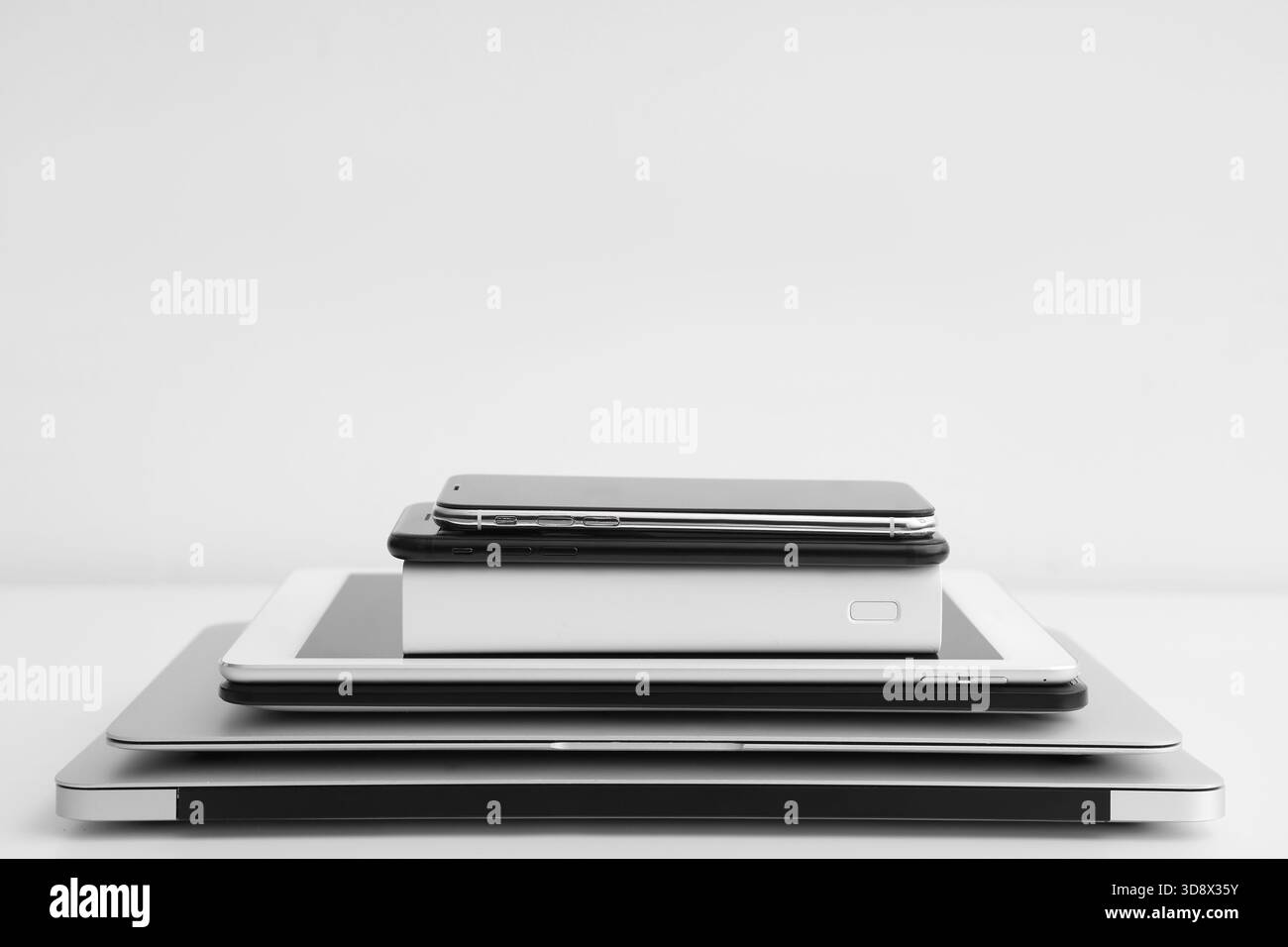 Stack of different modern gadgets on light background Stock Photo