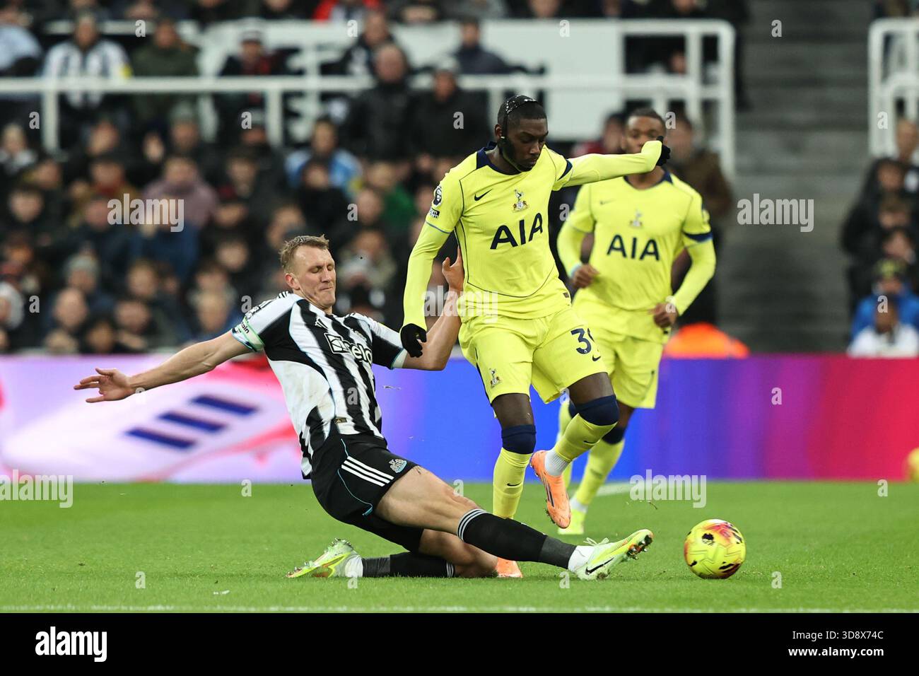 Randal Kolo Muani of Tottenham Hotspur is tackled by Dan Burn of Newcastle United during the Premier League match Newcastle United vs Tottenham Hotspur at St. James's Park, Newcastle, United Kingdom, 2nd December 2025  (Photo by Alfie Cosgrove/News Images)  *** GER AUT SUI OUT *** Stock Photo