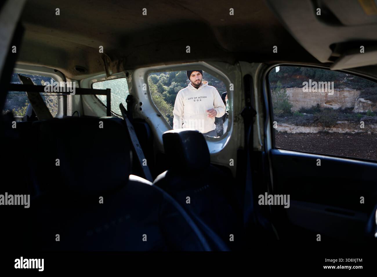 Hebron, West Bank city of Hebron. 2nd Dec, 2025. A Palestinian inspects the car of Muhannad Tariq Mohammad Al-Zgheer who was killed by the Israeli forces, in the West Bank city of Hebron, Dec. 2, 2025. The Palestinian Health Ministry said 17-year-old Muhannad Tariq Mohammad Al-Zgheer was shot dead in Hebron and that Israeli forces kept his body. Palestinian security officials said the shooting occurred as Israeli troops shut down northern checkpoints during a manhunt after an Israeli soldier was run over at a nearby military checkpoint. Credit: Mamoun Wazwaz/Xinhua/Alamy Live News Stock Photo