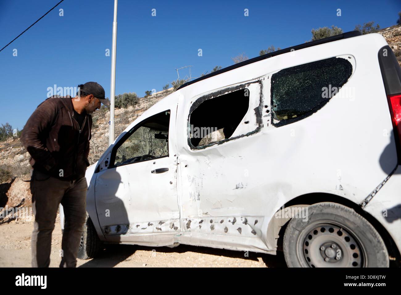 Hebron, West Bank city of Hebron. 2nd Dec, 2025. A Palestinian inspects the car of Muhannad Tariq Mohammad Al-Zgheer who was killed by the Israeli forces, in the West Bank city of Hebron, Dec. 2, 2025. The Palestinian Health Ministry said 17-year-old Muhannad Tariq Mohammad Al-Zgheer was shot dead in Hebron and that Israeli forces kept his body. Palestinian security officials said the shooting occurred as Israeli troops shut down northern checkpoints during a manhunt after an Israeli soldier was run over at a nearby military checkpoint. Credit: Mamoun Wazwaz/Xinhua/Alamy Live News Stock Photo