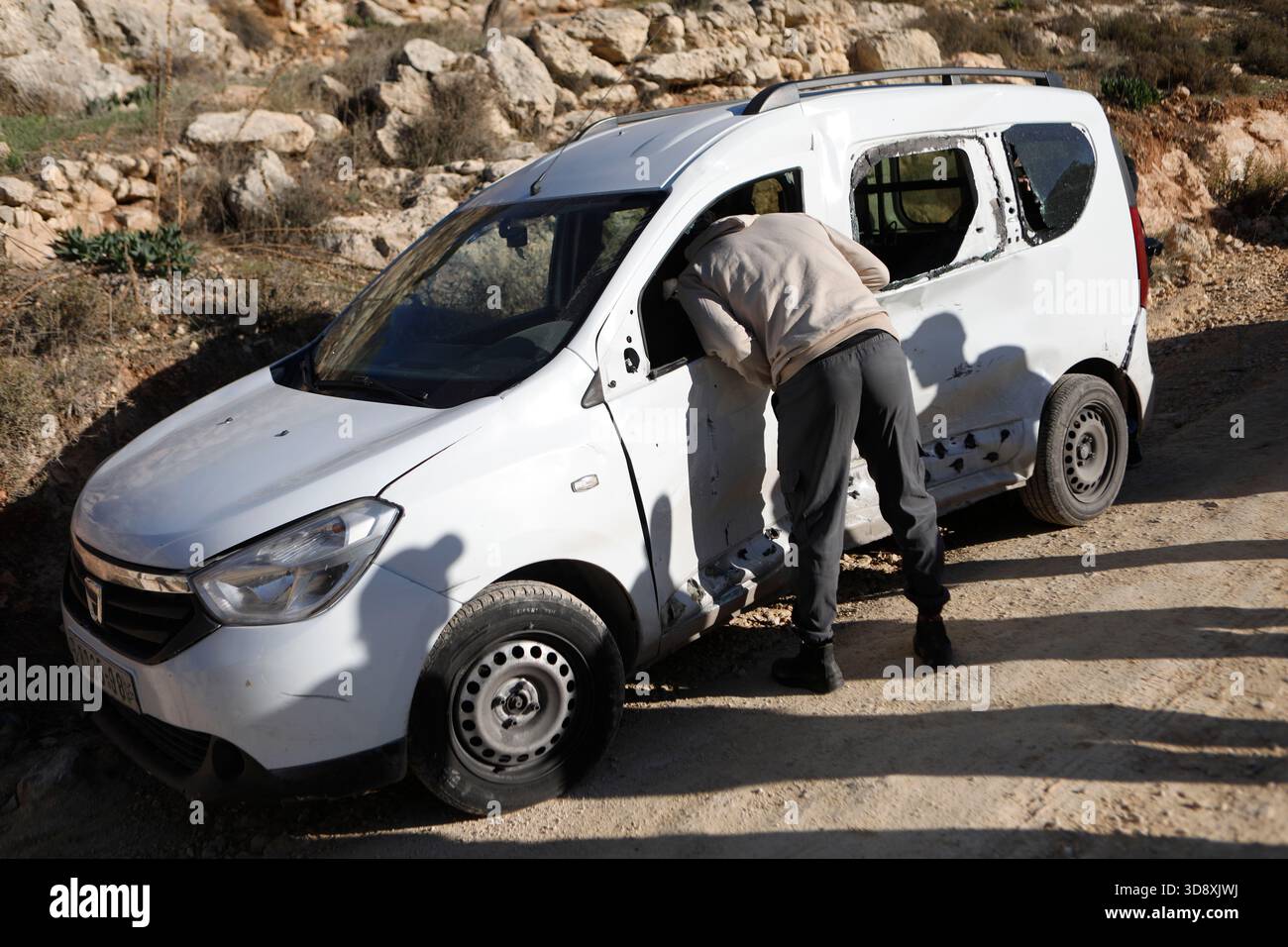 Hebron, West Bank city of Hebron. 2nd Dec, 2025. A Palestinian inspects the car of Muhannad Tariq Mohammad Al-Zgheer who was killed by the Israeli forces, in the West Bank city of Hebron, Dec. 2, 2025. The Palestinian Health Ministry said 17-year-old Muhannad Tariq Mohammad Al-Zgheer was shot dead in Hebron and that Israeli forces kept his body. Palestinian security officials said the shooting occurred as Israeli troops shut down northern checkpoints during a manhunt after an Israeli soldier was run over at a nearby military checkpoint. Credit: Mamoun Wazwaz/Xinhua/Alamy Live News Stock Photo