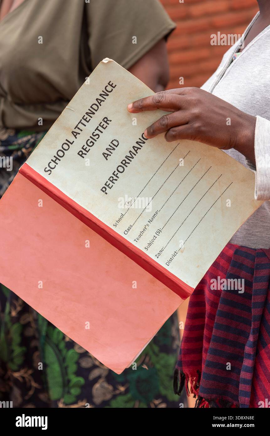 Lilongwe Malawi Africa. 10.11.2025.  Teachers hand holding  a school attendance register and performance record book. - Stock Image