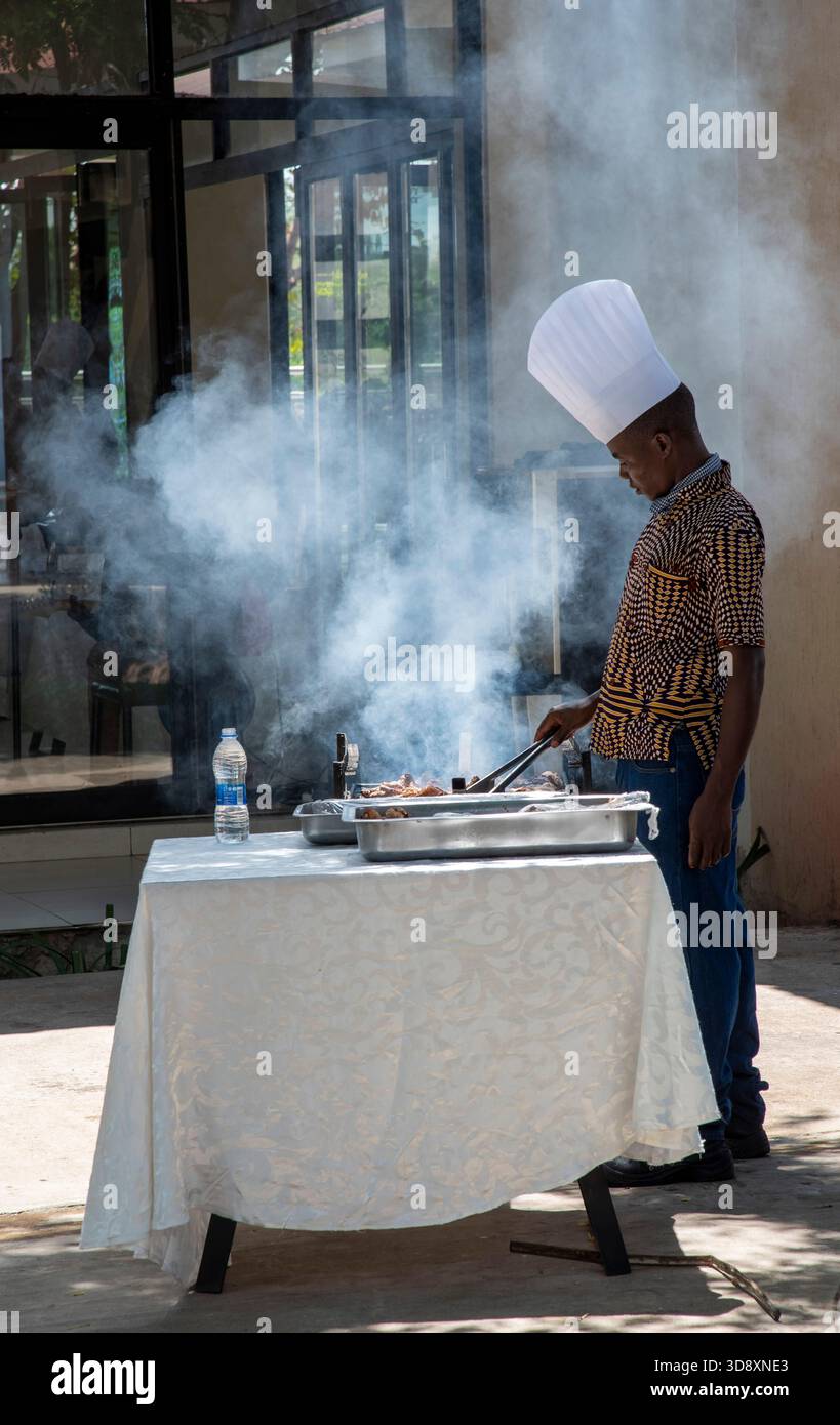 Maganga Malawi Africa.  11.11. 2025.  Chef in white hat cooking breakfast in a holiday hotel in Malawi southern Africa. - Stock Image