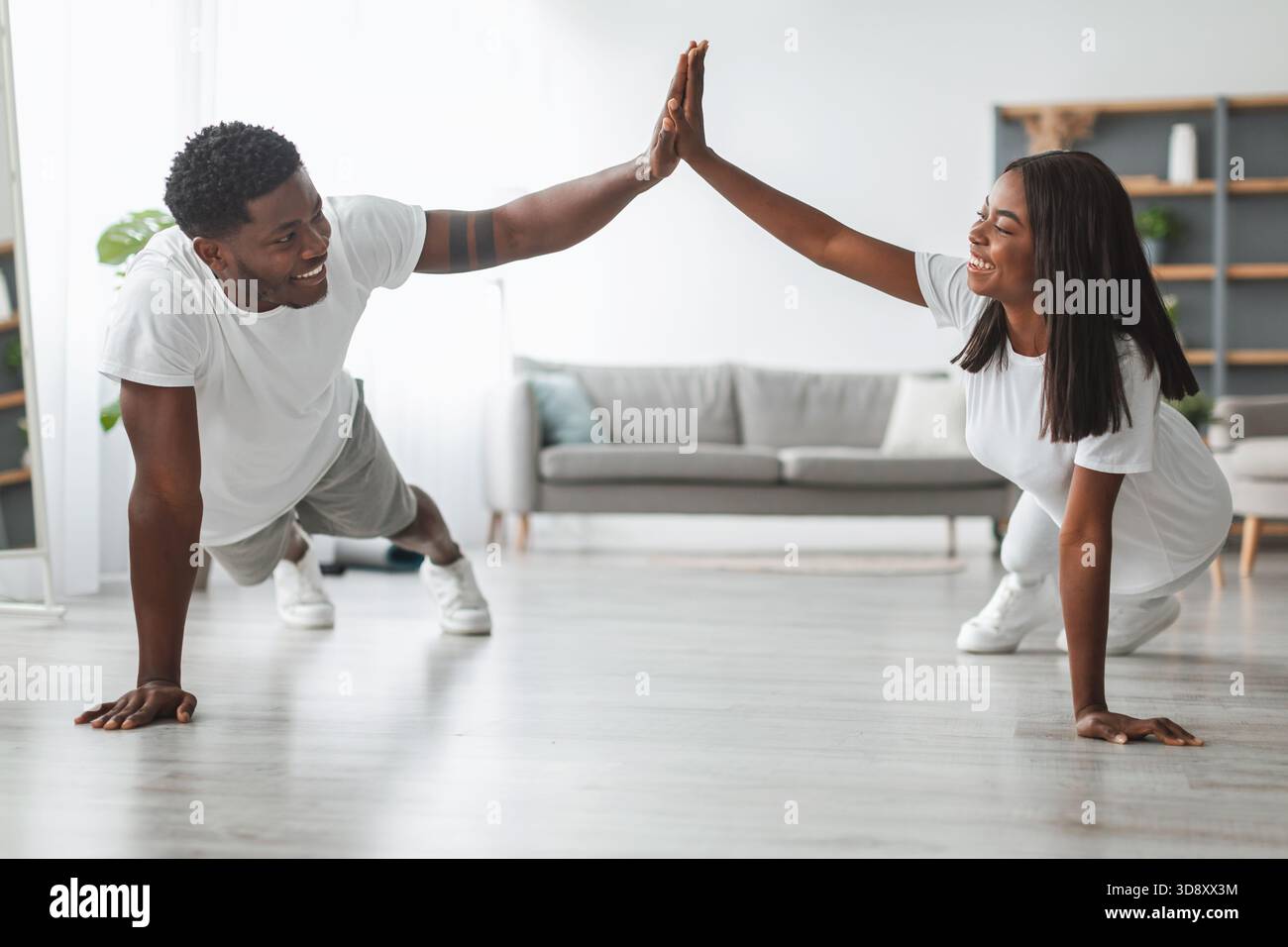Young black couple planking and giving high five Stock Photo