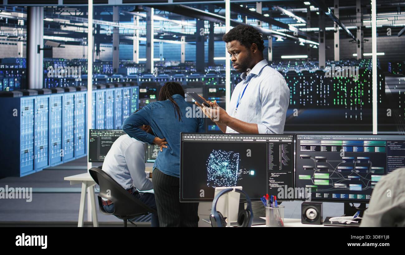 Data center technician using tablet to do node tree programming, optimizing resource allocation. Server room IT expert using predictive AI visualization systems for maintenance planning, camera A Stock Photo